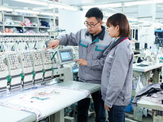 Operator training beside embroidery machine